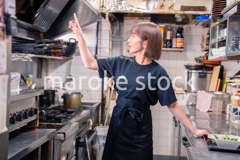 居酒屋の厨房で働くキッチンスタッフの女性