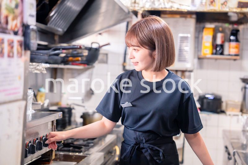 居酒屋の厨房で働くキッチンスタッフの女性