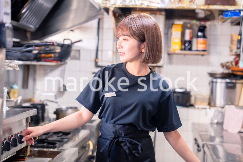 居酒屋の厨房で働くキッチンスタッフの女性