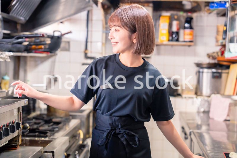 居酒屋の厨房で働くキッチンスタッフの女性