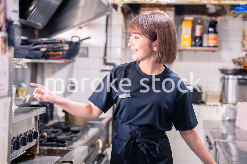 居酒屋の厨房で働くキッチンスタッフの女性
