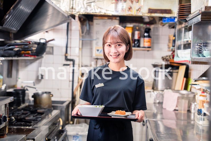 飲食店の厨房で働く若い女性のスタッフ