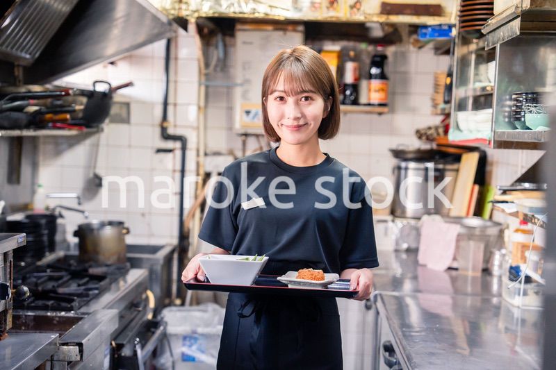 飲食店の厨房で働く若い女性のスタッフ