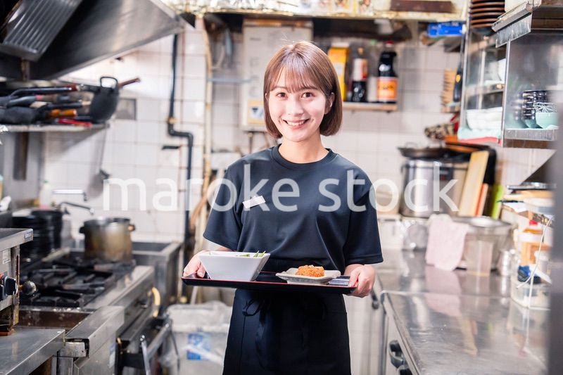 飲食店の厨房で働く若い女性のスタッフ