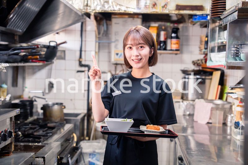 飲食店の厨房で働く若い女性のスタッフ