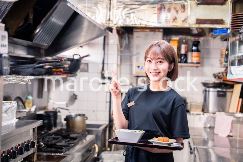 飲食店の厨房で働く若い女性のスタッフ