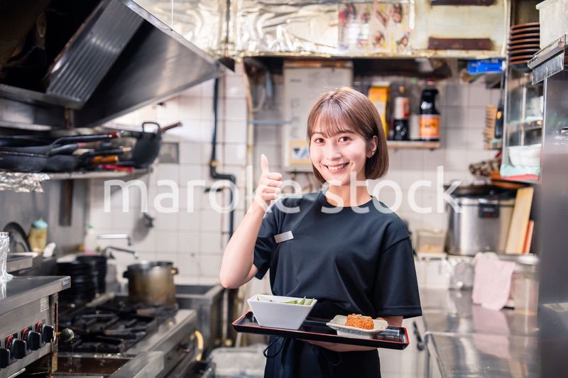 飲食店の厨房で働く若い女性のスタッフ