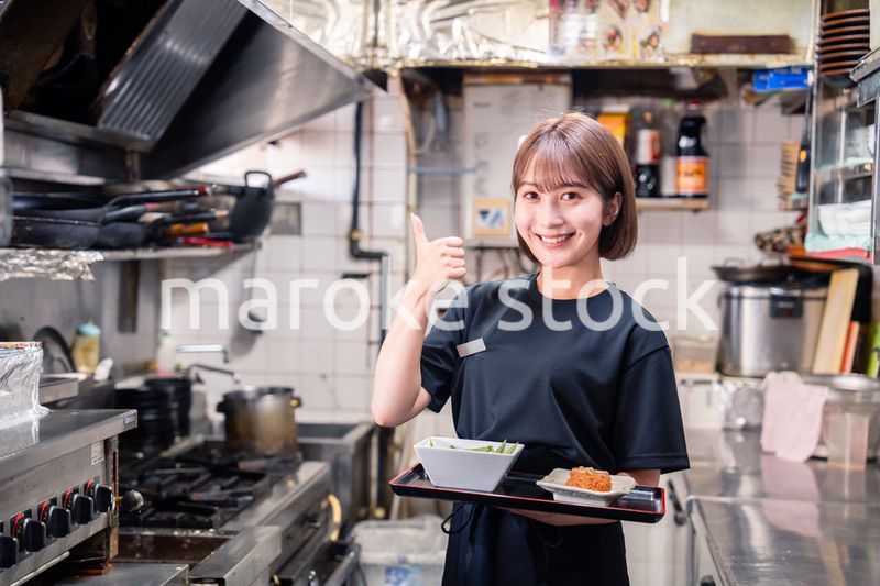 飲食店の厨房で働く若い女性のスタッフ