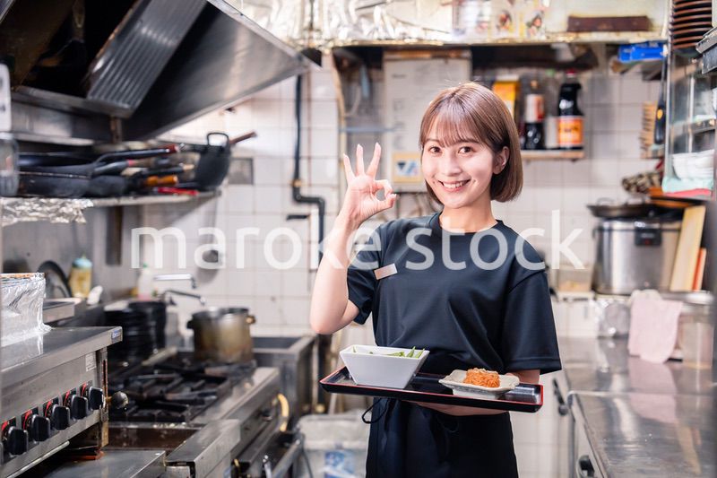 飲食店の厨房で働く若い女性のスタッフ
