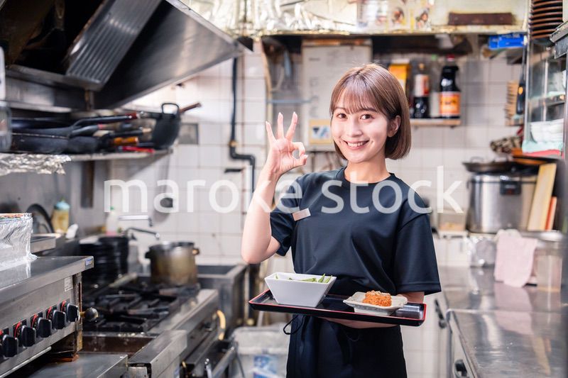 飲食店の厨房で働く若い女性のスタッフ