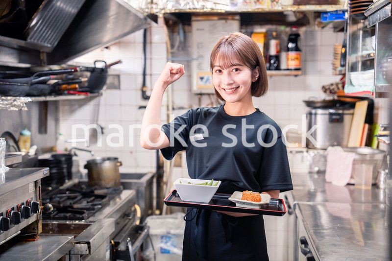 飲食店の厨房で働く若い女性のスタッフ