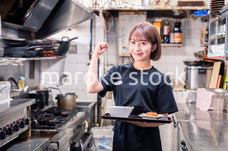 飲食店の厨房で働く若い女性のスタッフ