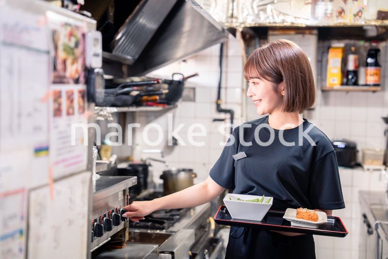 飲食店の厨房で働く若い女性のスタッフ