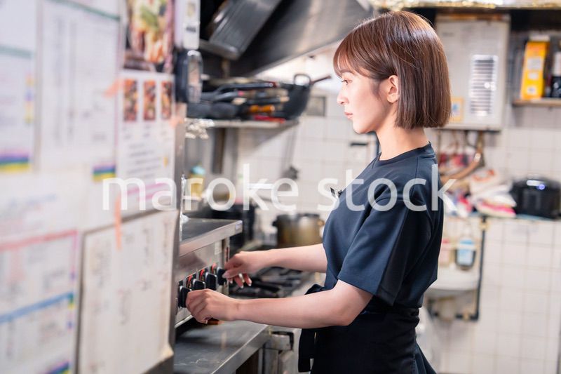 居酒屋の厨房で働くキッチンスタッフの女性