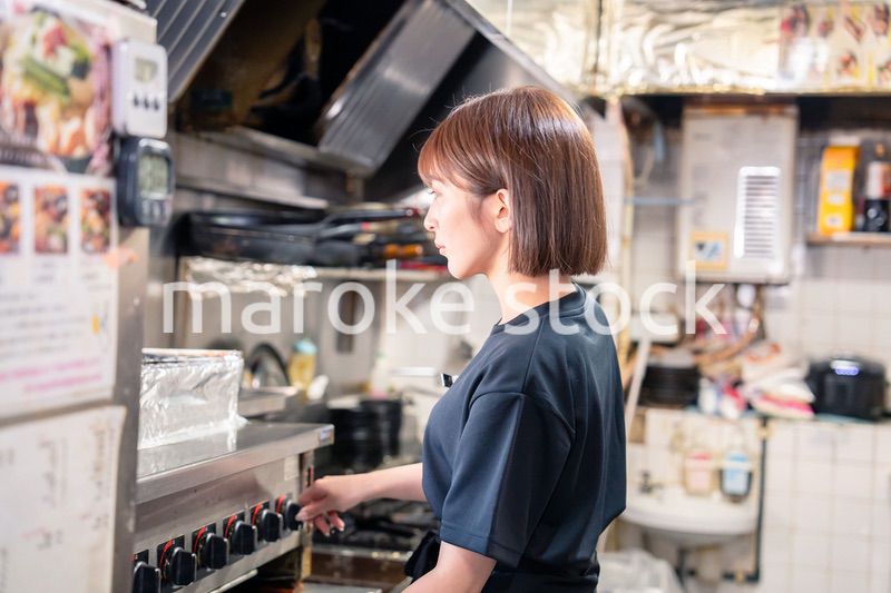 居酒屋の厨房で働くキッチンスタッフの女性