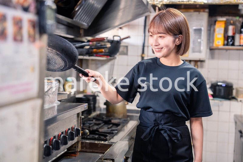 居酒屋の厨房で働くキッチンスタッフの女性