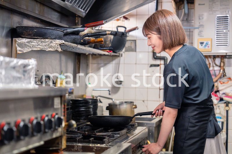 居酒屋の厨房で働くキッチンスタッフの女性