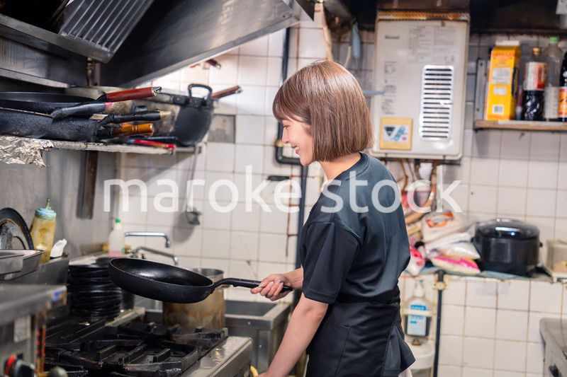 居酒屋の厨房で働くキッチンスタッフの女性