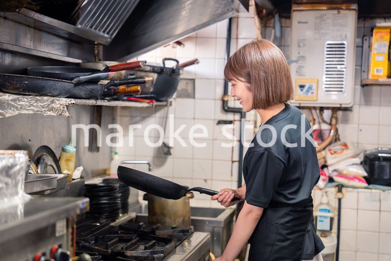 居酒屋の厨房で働くキッチンスタッフの女性