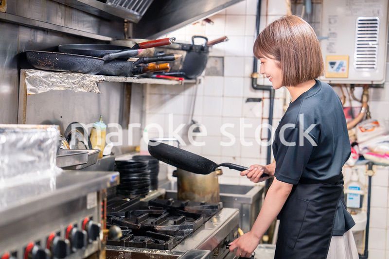 居酒屋の厨房で働くキッチンスタッフの女性
