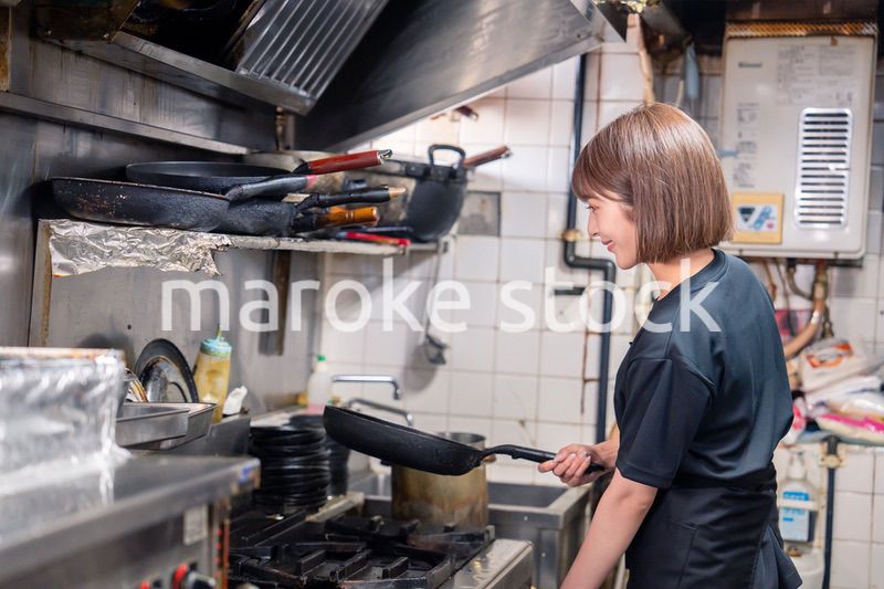 居酒屋の厨房で働くキッチンスタッフの女性
