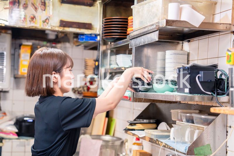 居酒屋の厨房で働くキッチンスタッフの女性
