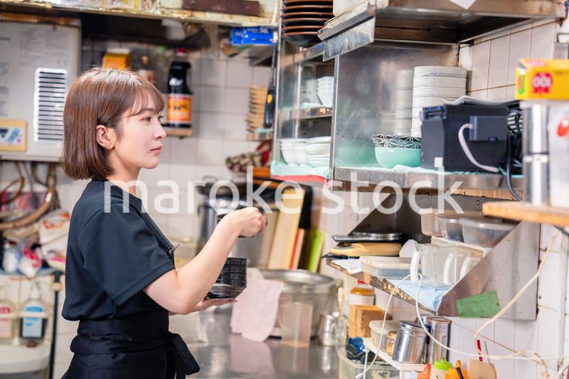 居酒屋の厨房で働くキッチンスタッフの女性