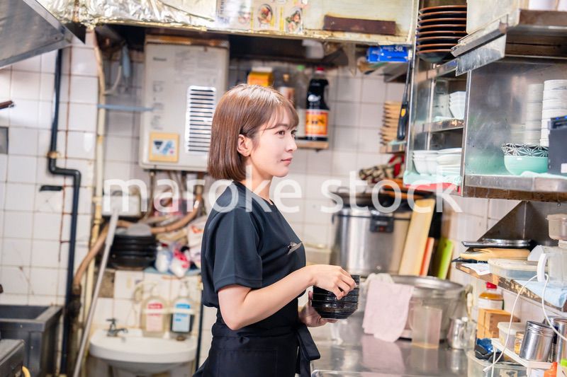 居酒屋の厨房で働くキッチンスタッフの女性