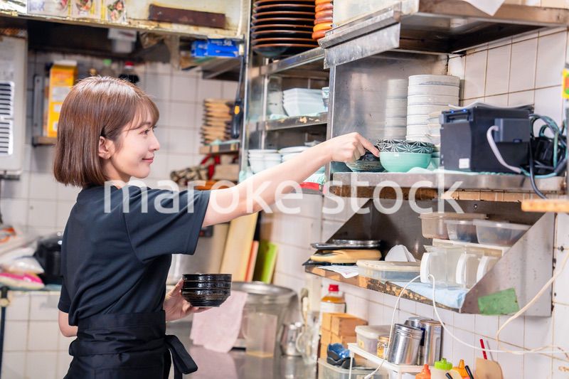 居酒屋の厨房で働くキッチンスタッフの女性