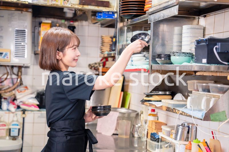 居酒屋の厨房で働くキッチンスタッフの女性