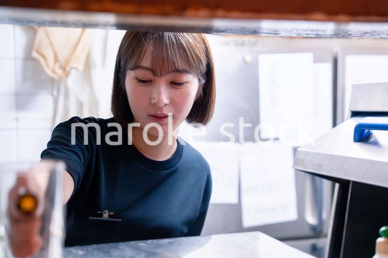 業務用の食洗機でお皿洗いをする飲食店スタッフ