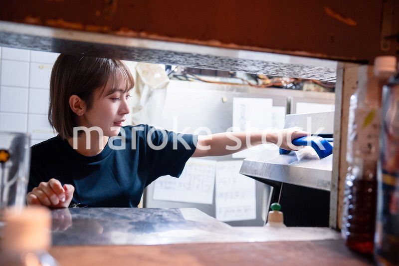 業務用の食洗機でお皿洗いをする飲食店スタッフ