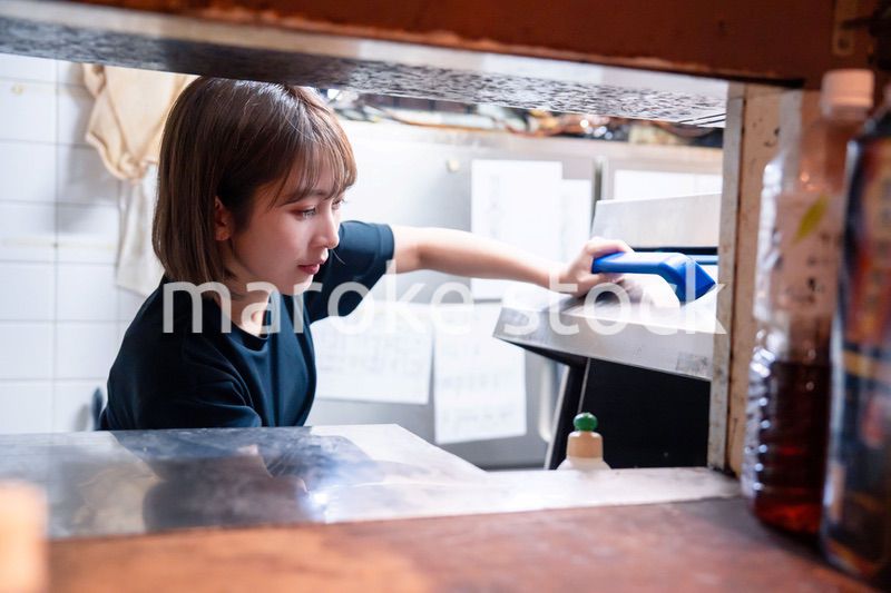 業務用の食洗機でお皿洗いをする飲食店スタッフ