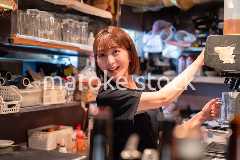 飲食店でビールサーバーを使う女性の店員