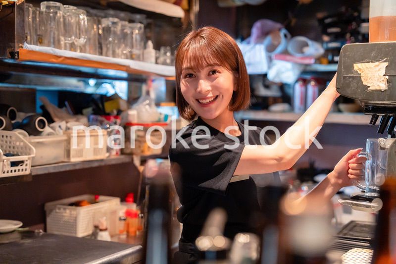 飲食店でビールサーバーを使う女性の店員
