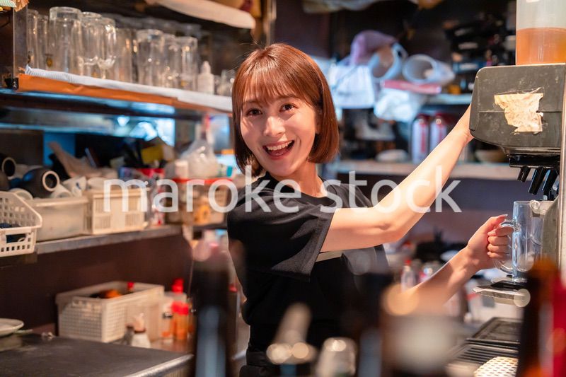 飲食店でビールサーバーを使う女性の店員
