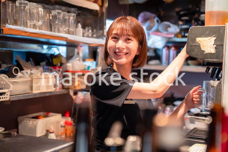 飲食店でビールサーバーを使う女性の店員