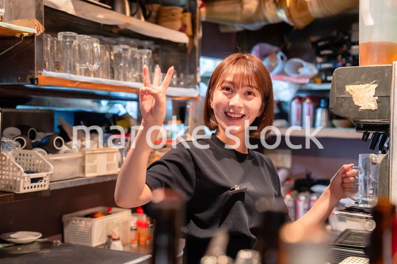 飲食店でビールサーバーを使う女性の店員