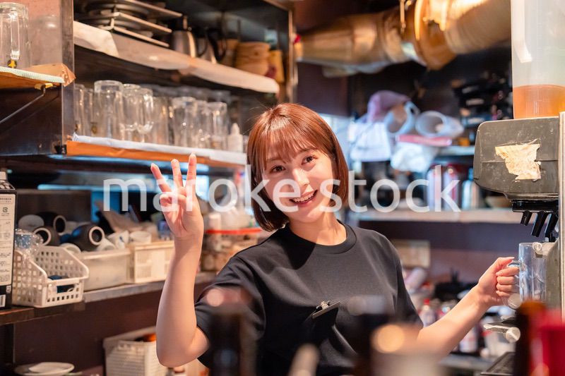 飲食店でビールサーバーを使う女性の店員