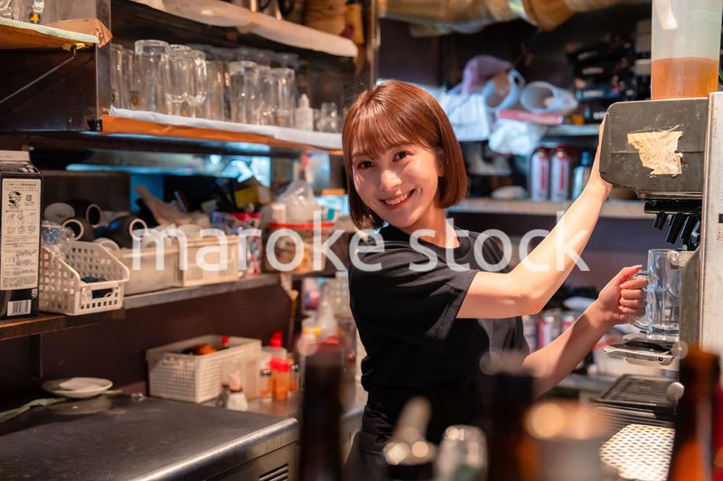 飲食店でビールサーバーを使う女性の店員