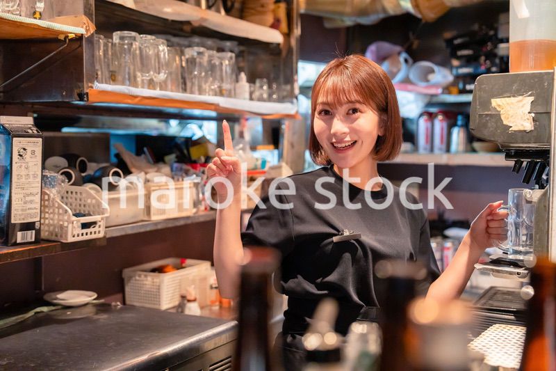 飲食店でビールサーバーを使う女性の店員