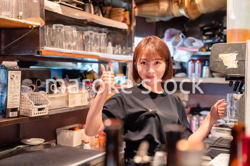 飲食店でビールサーバーを使う女性の店員