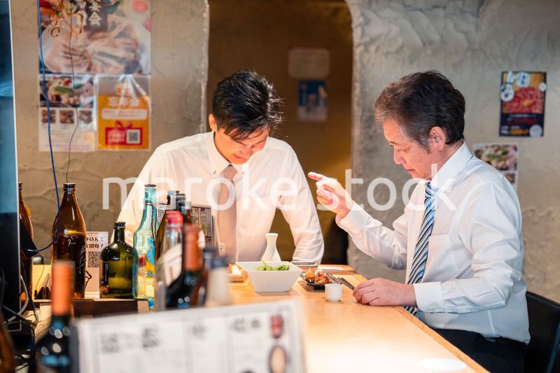 居酒屋で部下の説教をする上司