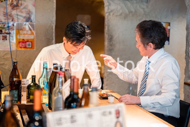 居酒屋で部下の説教をする上司