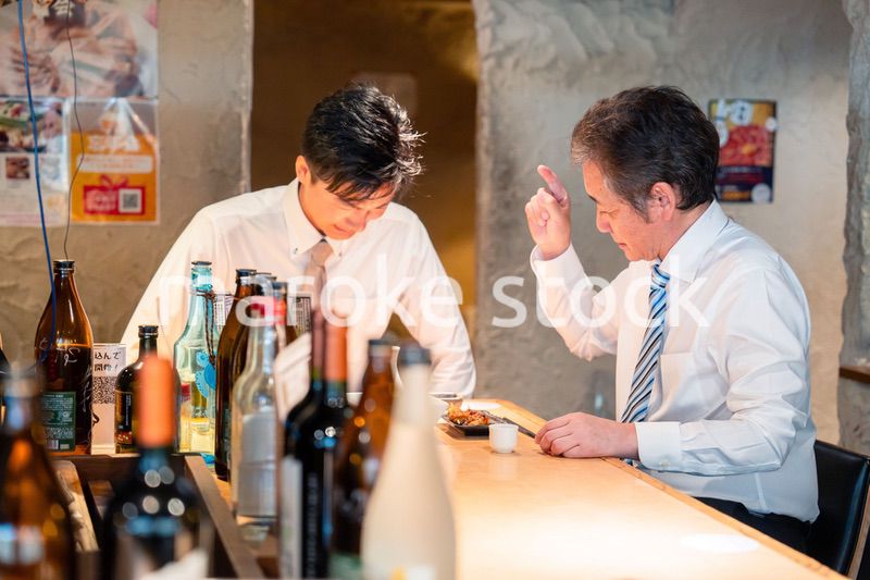 居酒屋で部下の説教をする上司