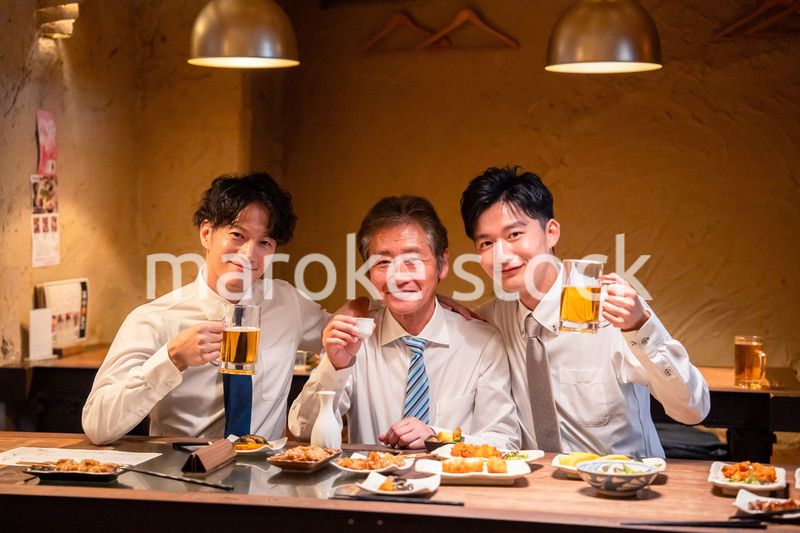 上司と肩を組みながら居酒屋で飲むサラリーマン