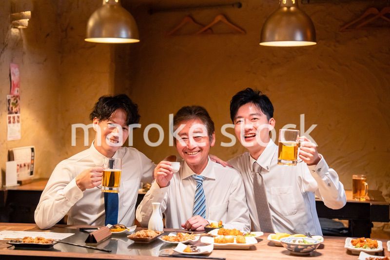 上司と肩を組みながら居酒屋で飲むサラリーマン