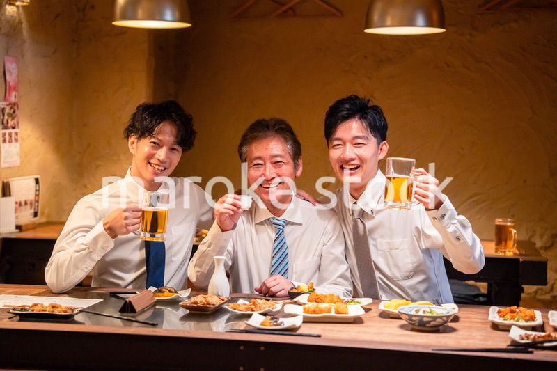 上司と肩を組みながら居酒屋で飲むサラリーマン