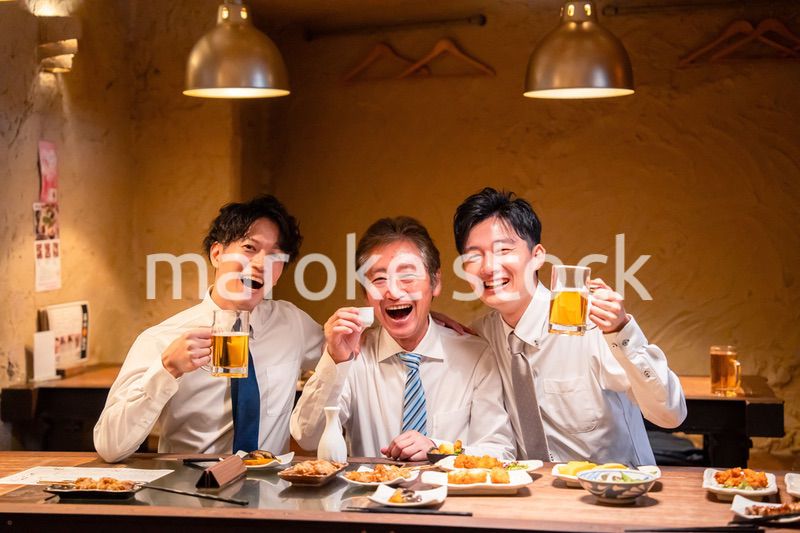 上司と肩を組みながら居酒屋で飲むサラリーマン