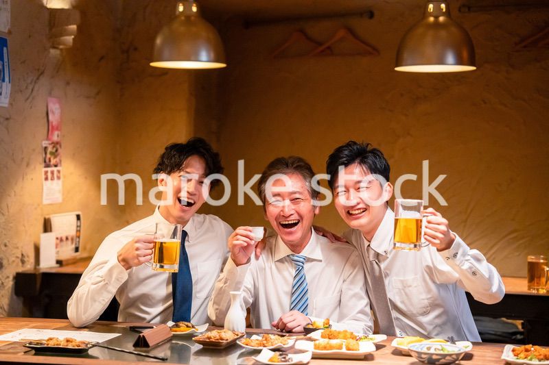 上司と肩を組みながら居酒屋で飲むサラリーマン